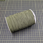 Spool of green thread on a grid background