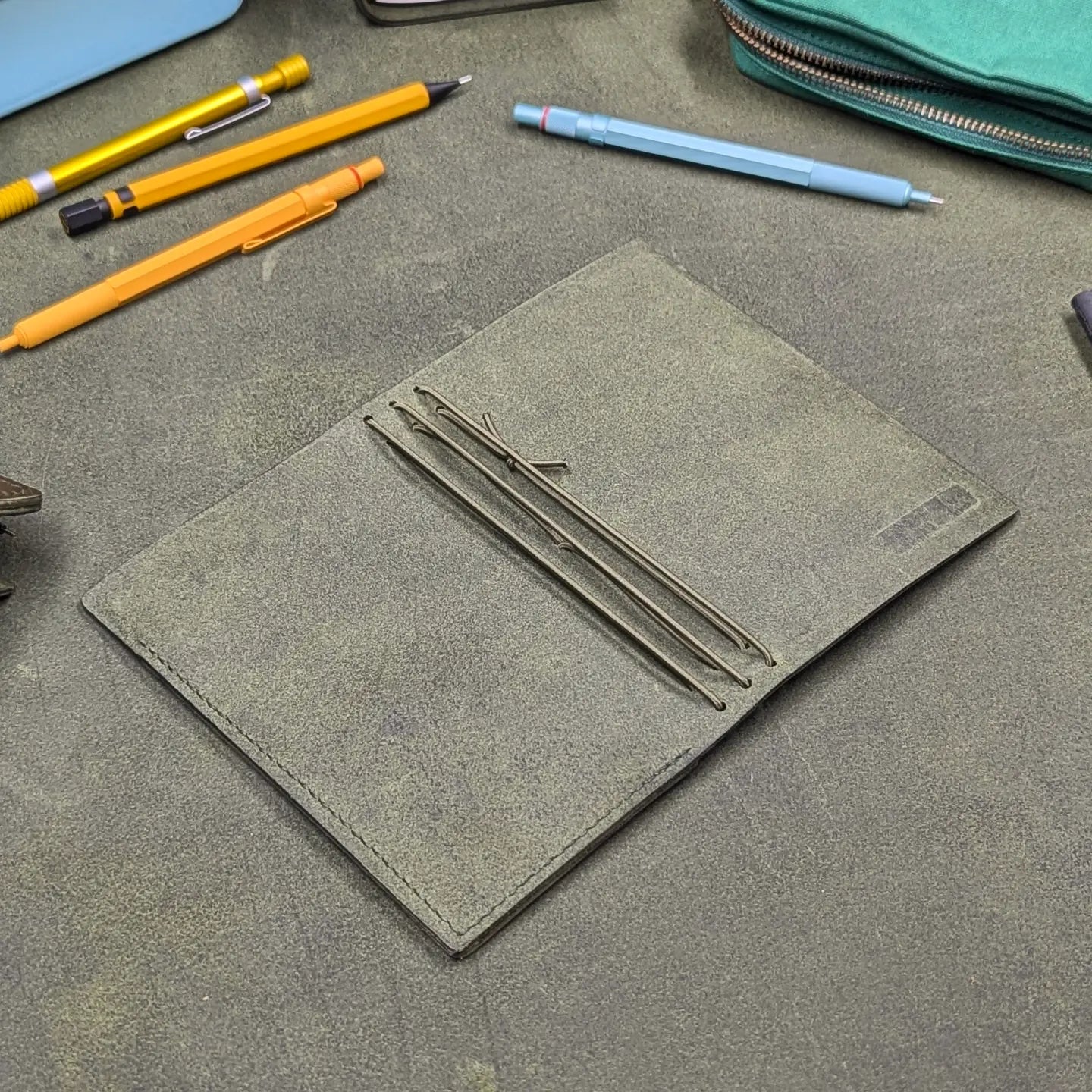 Traveller's notebook cover open to show three sets of interior elastics 