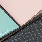 Close up of brown leather notebook cover open holding three notebook inserts